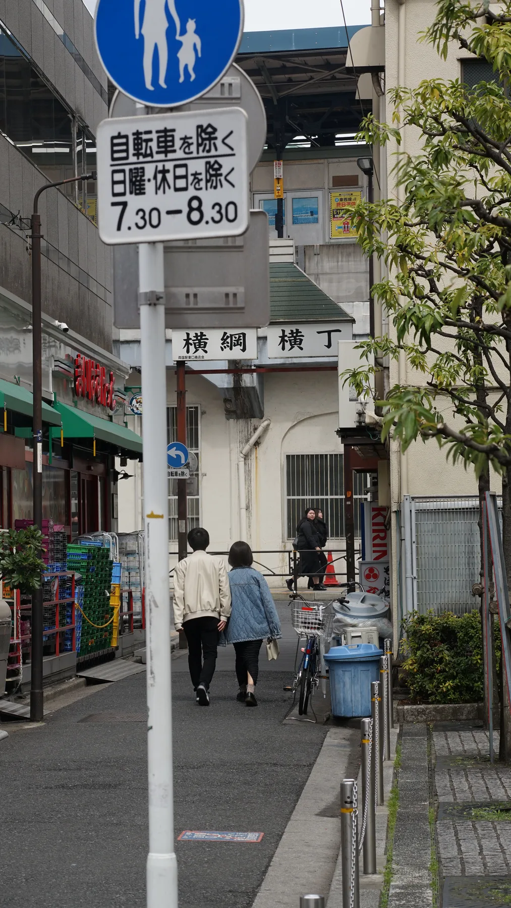 Straßenszene mit japanischen Schildern und Passanten in Yokozuna